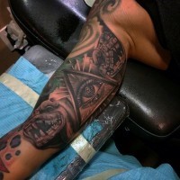 Antic style black ink biceps tattoo of dragon statues with triangle and eye