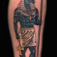 Anubis colored ink tattoo on arm