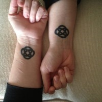 Tatuajes en las muñecas,
signo celta grueso de color negro para amigos