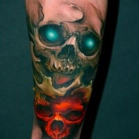 Tatouage d'avant-bras coloré de style art de crânes démoniaques avec des yeux brillants