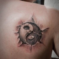Asiatisches verblasstes Yin Yang spezielles Symbol in die Haut mit Rissen 3D realistisches Tattoo am Schulterblatt