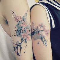 Asiatischer Stil schön gestaltetes buntes Blumen Tattoo an der Schulter mit Schriftzug
