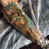 Tatuaje en el antebrazo,
dragón verde divertido en estilo asiático