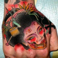 Asian style colored monster geisha face tattoo on hand