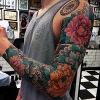 Tatuaje en el brazo completo, montón de flores de colores diferentes, estilo asiático