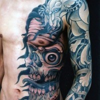 Asian style half colored monster skull with goat tattoo on sleeve and chest