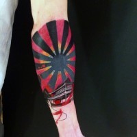 Tatuaje en el antebrazo, sol estilizado de colores negro y rojo, estilo asiático