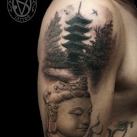 Asian themed black and white shoulder tattoo of Buddha statue and old temple