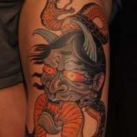 Asian traditional colored thigh tattoo of demonic face with snake
