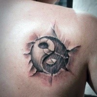 Asian Yin Yang cracked symbol tattoo on man's shoulder blade in 3D style