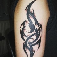 Asiatisches Yin Yang spezielles Symbol mit dunklen schwarzen im Tribal Stil Elementen Tattoo auf der Schulter