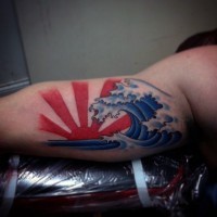 Tatuaje en el brazo, sol rojo y ola azul grande, estilo asiático
