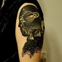 Tatuaje en el brazo, silueta de hombre con cosmos de colores negro y blanco