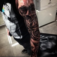 Awesome black and white human skull tattoo on sleeve with big rose