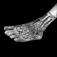 Tatuaje en el pie, inscripción y fecha de colores negro y blanco