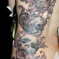 Awesome black gray patterns with skulls tattoo on ribs