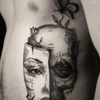 Tatuaje en las costillas,
cráneo con parte de máscara