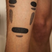 Awesome black ink funny face shaped tattoo on forearm