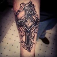 Erschütterndes Tattoo von Kreuz mit Initiale am Unterarm