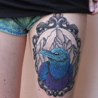 Tatuaje en el muslo,  pájaro fantástico azul en el marco