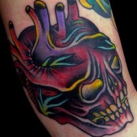 Awesome designed multicolored skull shaped heart tattoo on arm