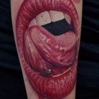 Awesome detailed and colored bloody vampire mouth with pierced tongue tattoo on arm
