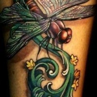 Tatuaje en el antebrazo, libélula  grande magnífica en el tallo