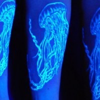 Tatuaje en el antebrazo, medusa grande larga de tinta ultravioleta