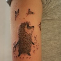 Tatuaje en el brazo,
erizo con bulto y mariposas, diseño gris