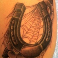 Awesome horseshoe with spider web and flowers tattoo