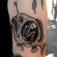 Tatuaje en el brazo, esqueleto en el estómago de pez
