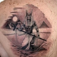 Awesome painted black and white Egypt God tattoo on back with pyramids