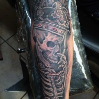 Tatuaje en el brazo, esqueleto de rey en corona preciosa que fuma