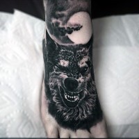 Tatuaje en el pie, lobo amenazante y la luna llena