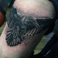Tatuaje en el muslo,  cuervo realista con alas extendidas