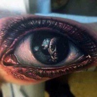 Awesome portrait of a man in human eye tattoo on arm