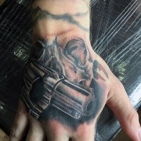 Awesome realism style colored revolver tattoo combined with human skull