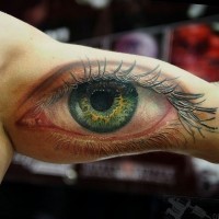 Awesome realistic green eye tattoo by Cris Gherman