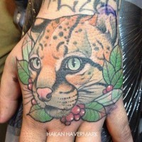 Tatuaje en la mano,  leopardo en hojas verdes
