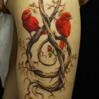 Tatuaggio sulla gamba due uccelli rossi & la chiave di viola di legno