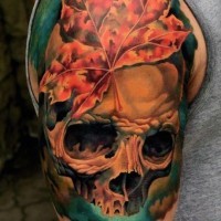 Tatuaje en el brazo, cráneo humano volumétrico con hoja de arce y luz verde brillante