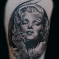 Awesome very realistic black and white smoking Merlin Monroe portrait tattoo on thigh