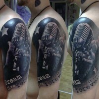 El micrófono obsoleto muy espectacular y realístico realizado en negro y blanco con una inscripción tatuaje en el antebrazo