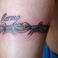 Barbed wire and name tattoo on arm