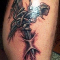 Tatuaje en la pierna,
alambre de espina con cruz