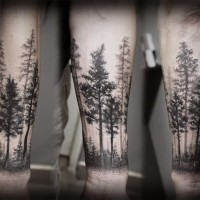 Tatuaje de  pinos oscuros en el antebrazo