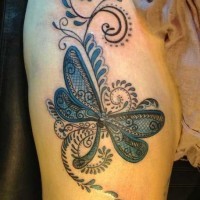 Tatuaje en la pierna, libélula de colores negro y azul oscuros, patchwork