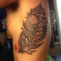 Beautiful gray-ink tribal feather tattoo on rib-side