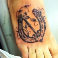 Beautiful horseshoe and key foot tattoo