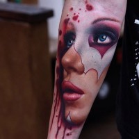 Tatuaje en el antebrazo,
cara de mujer en máscara y sangre